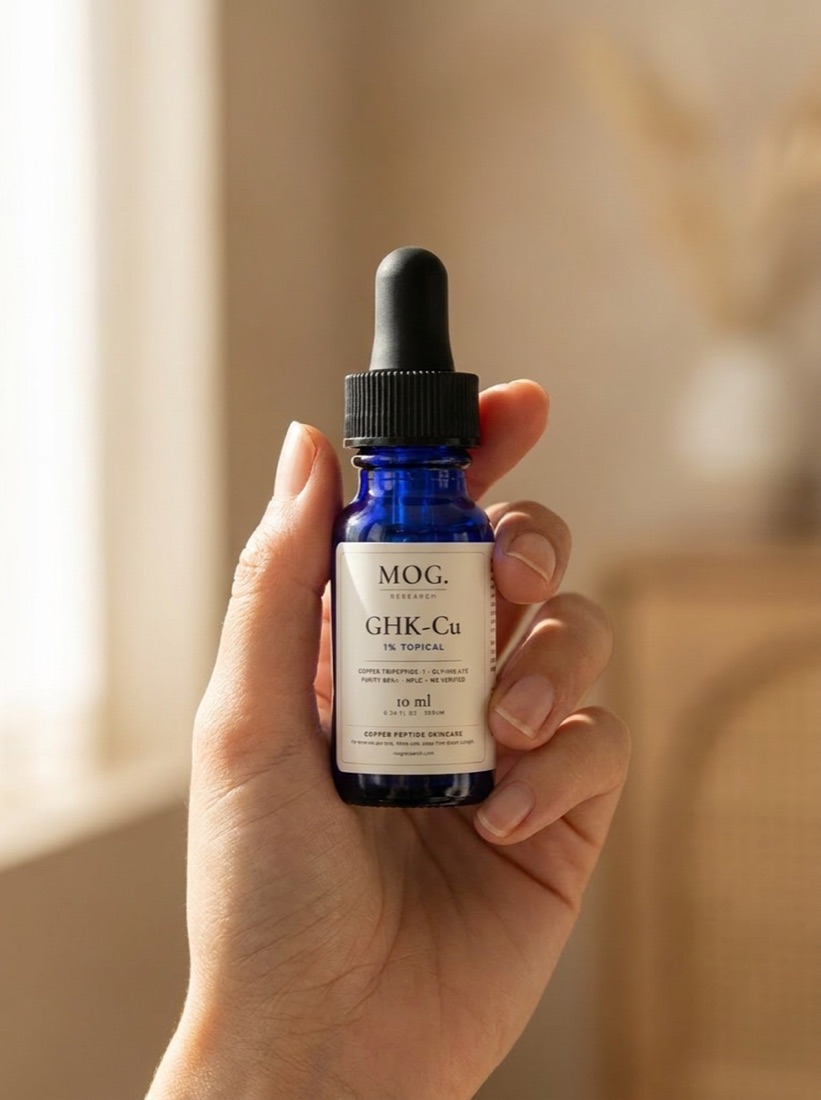 A hand holding the MOG Glow Peptide Serum dropper bottle